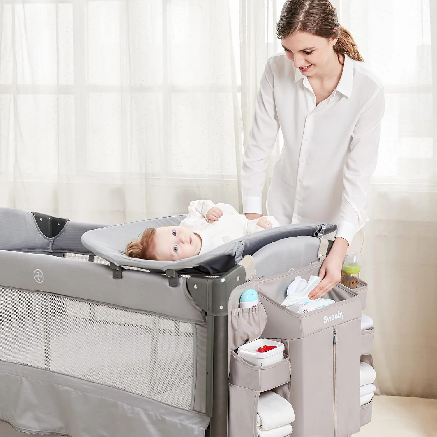A caddy on the rail keeps the diapers and wipes at arm's length before the change starts.